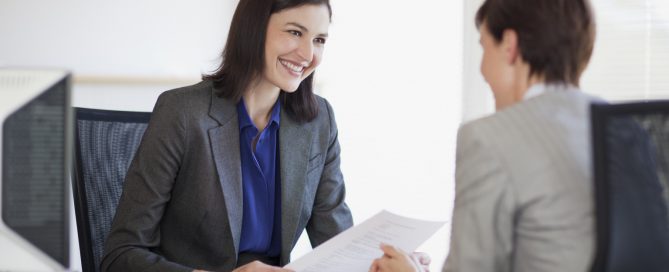 Businesswomen with paperwork talking face to face